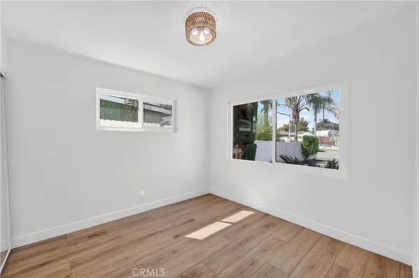 an empty room with wooden floor and window