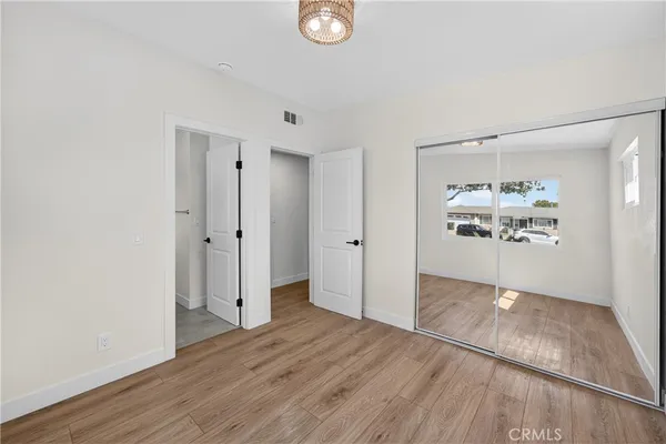 an empty room with wooden floor and window