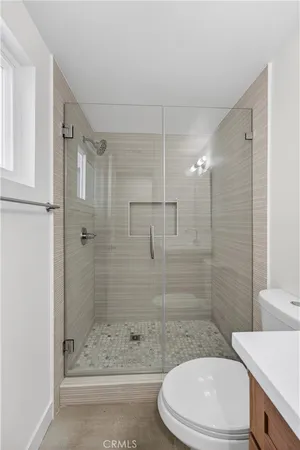 a bathroom with a sink a toilet and shower