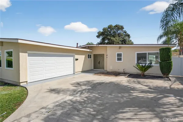 a view of a house with backyard and bushes