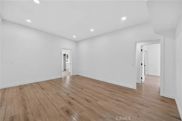 a view of an empty room with wooden floor