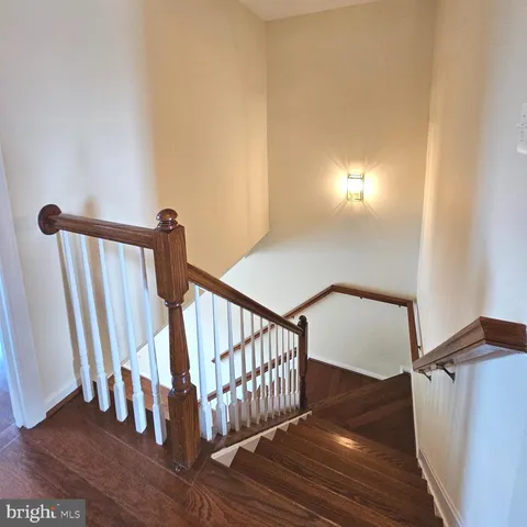 a view of staircase with railing and a rug