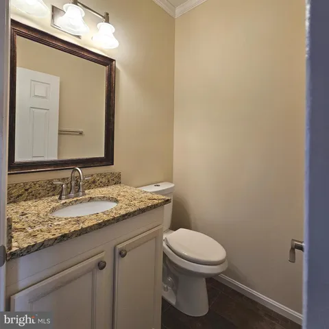 a bathroom with a granite countertop toilet and a sink