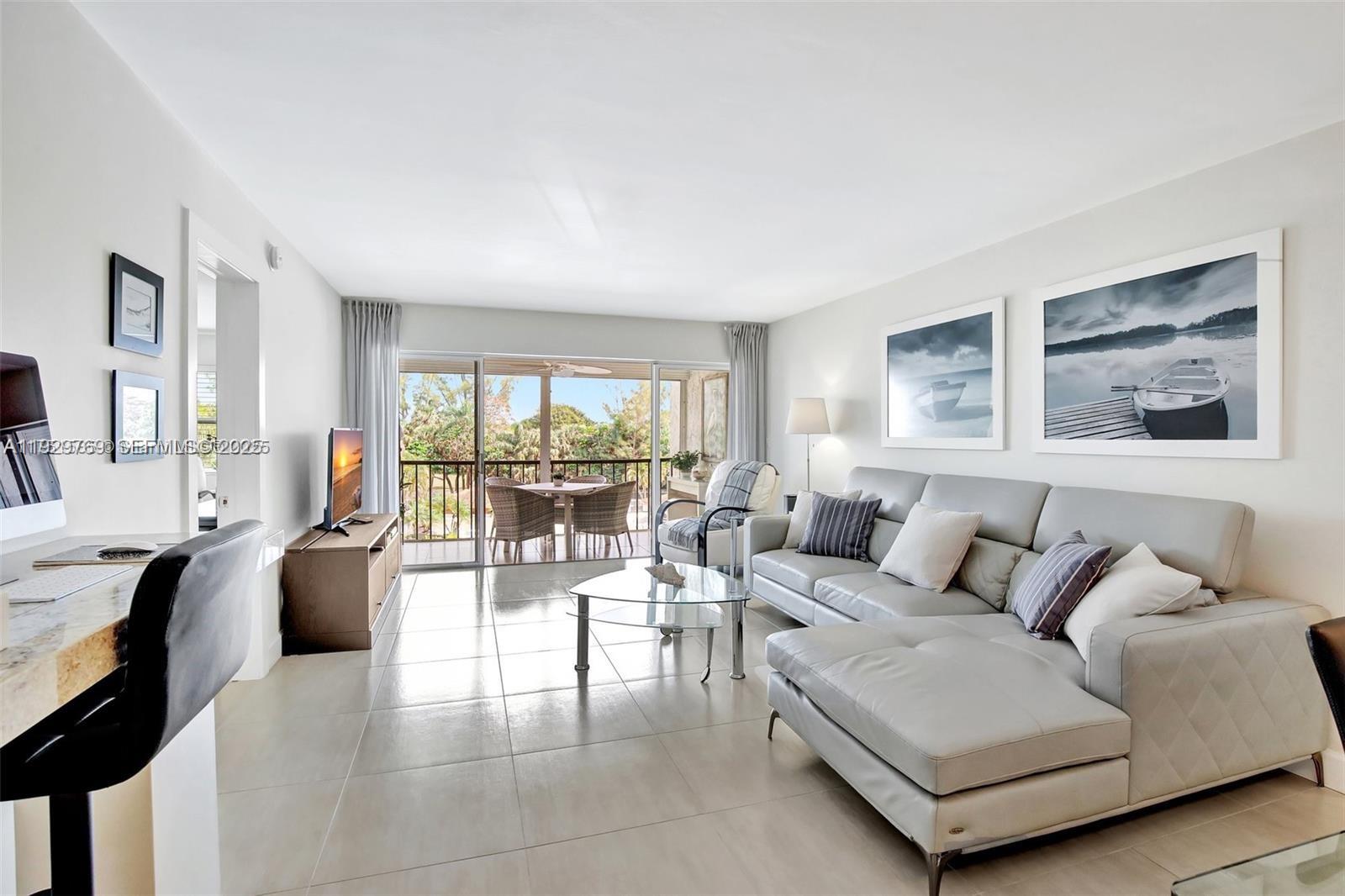 3930 Inverrary Boulevard, Unit 405D Lauderhill, FL 33319 - Photo 11 of 46 a living room with furniture and a large window