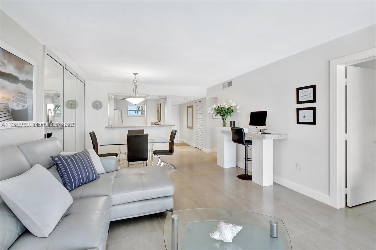 3930 Inverrary Boulevard, Unit 405D Lauderhill, FL 33319 - Photo 14 of 46 a living room with furniture and a flat screen tv