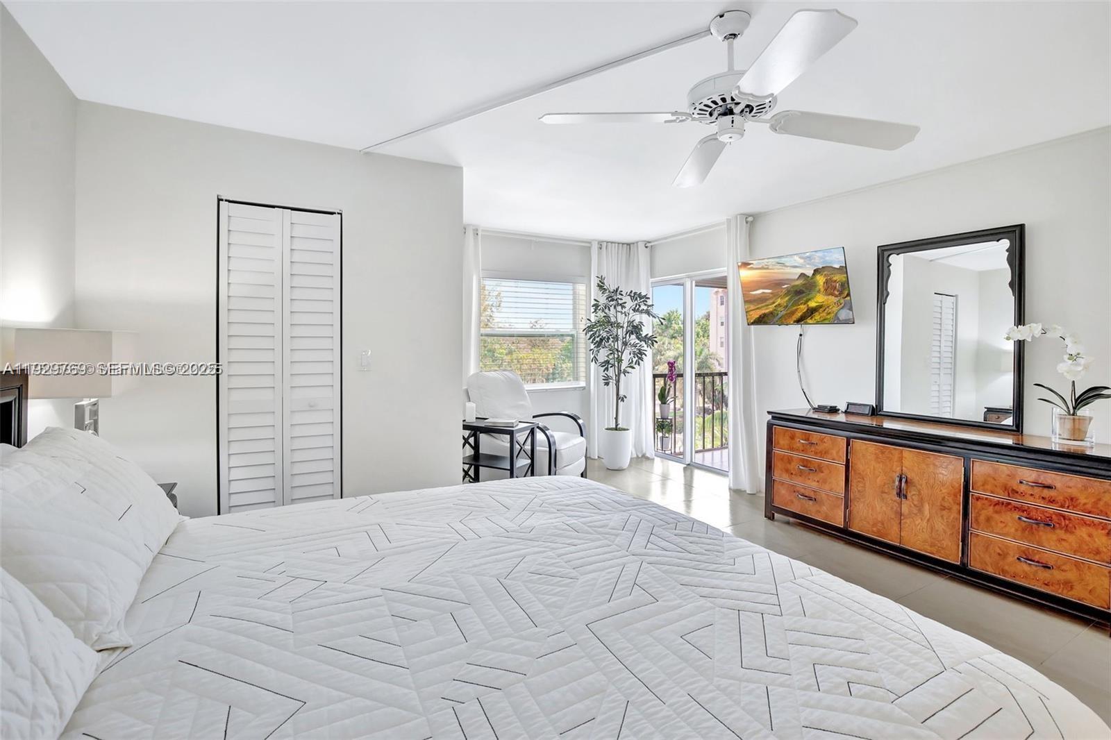 3930 Inverrary Boulevard, Unit 405D Lauderhill, FL 33319 - Photo 19 of 46 a large bedroom with a large bed and a chandelier