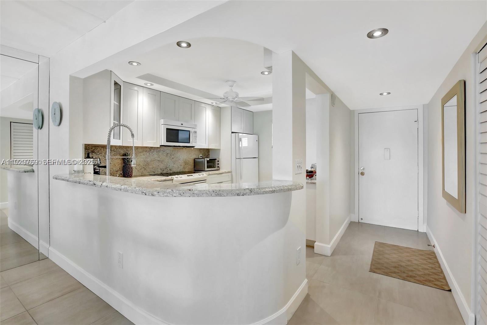 3930 Inverrary Boulevard, Unit 405D Lauderhill, FL 33319 - Photo 2 of 46 a view of kitchen island a sink wooden floor and living room