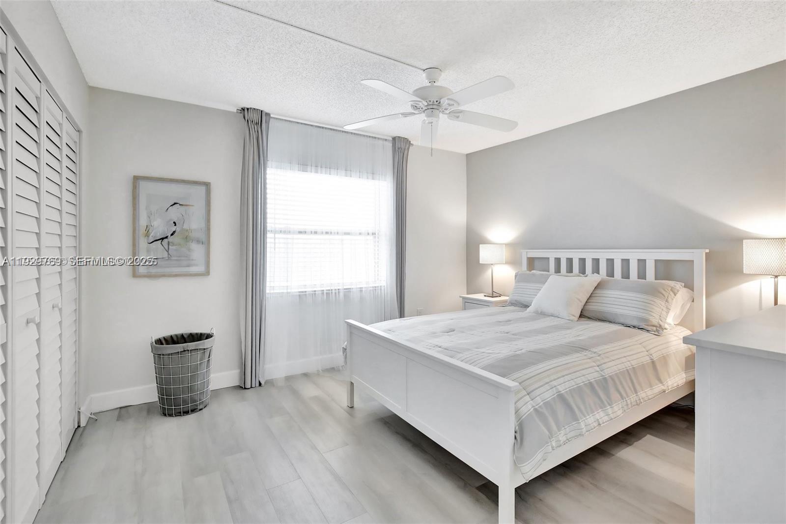 3930 Inverrary Boulevard, Unit 405D Lauderhill, FL 33319 - Photo 27 of 46 a bedroom with a large bed and a chandelier