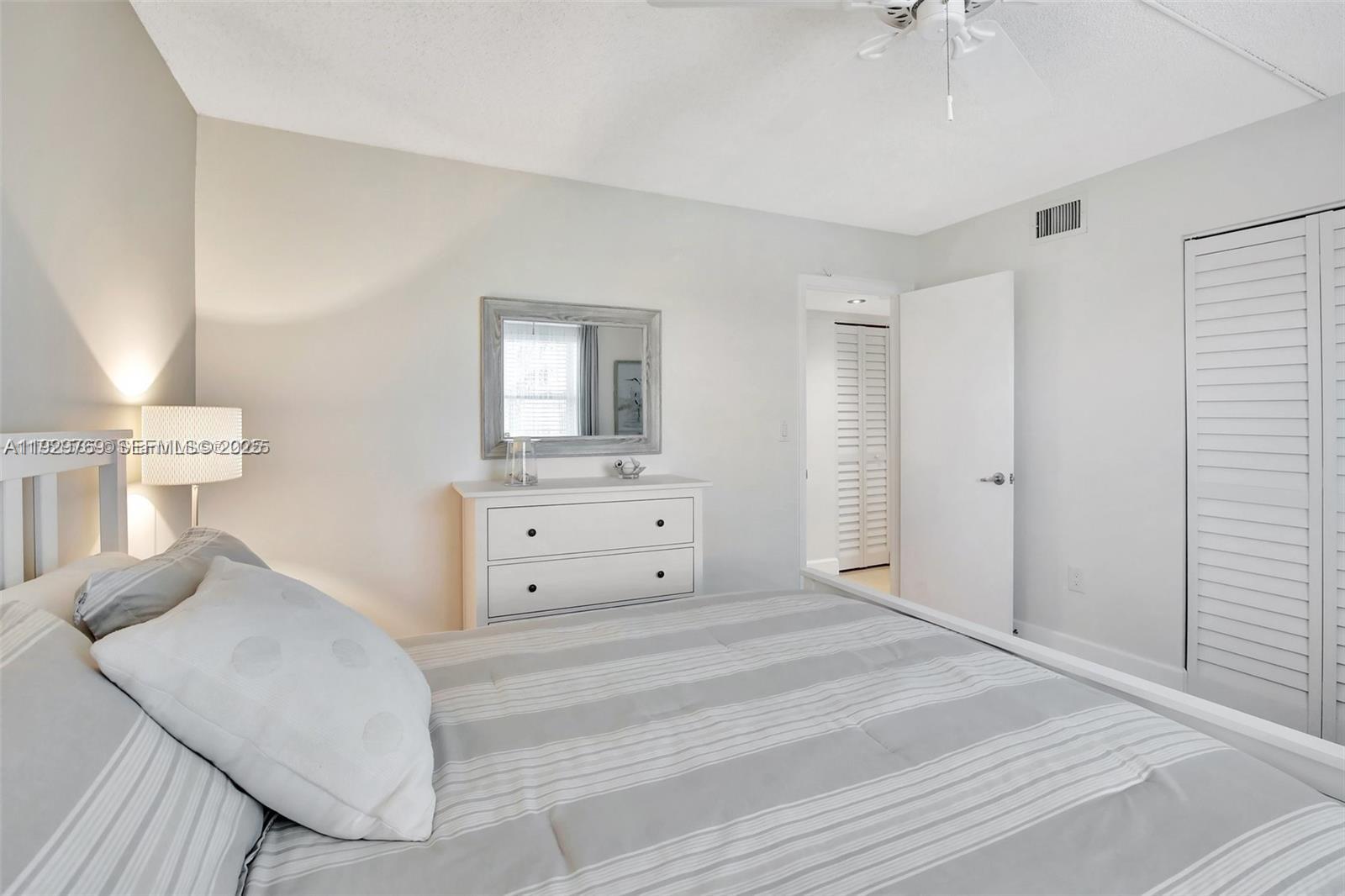 3930 Inverrary Boulevard, Unit 405D Lauderhill, FL 33319 - Photo 29 of 46 a room with a bed and a mirror