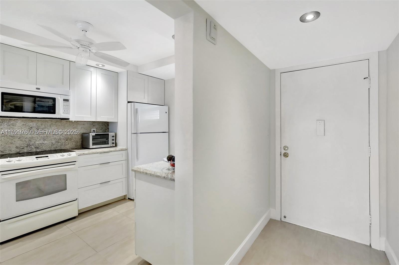 3930 Inverrary Boulevard, Unit 405D Lauderhill, FL 33319 - Photo 3 of 46 a kitchen with white cabinets and stainless steel appliances