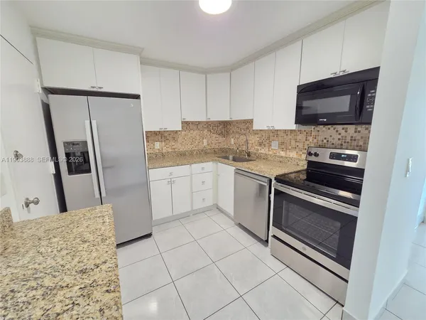 a kitchen with stainless steel appliances a stove a microwave and a sink