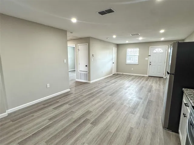 an empty room with wooden floor and a window