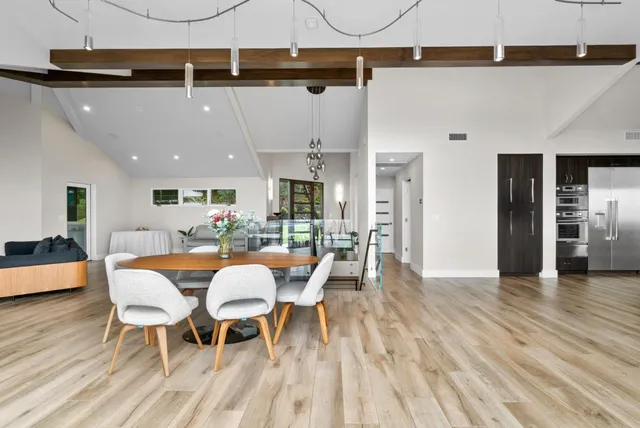 a view of a patio with couches table and chairs with wooden floor