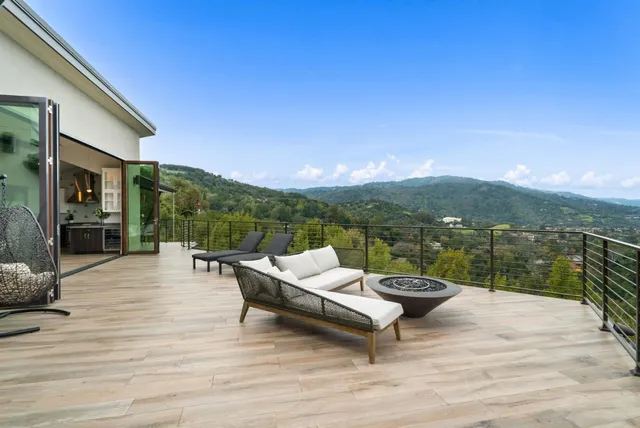 a view of a kitchen with kitchen island a sink wooden floor and living room view