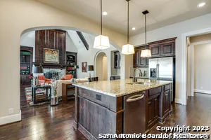 a large kitchen with kitchen island a stove a sink a dining table and chairs