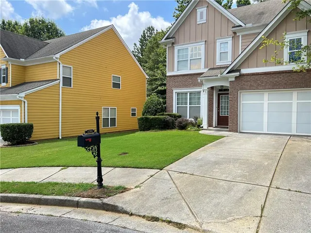 a front view of a house with a garden and plants