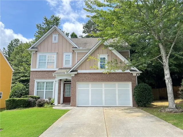 a front view of a house with a yard and garage