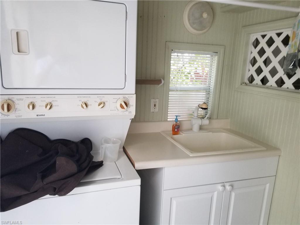 4914 Coach Lane Naples, FL 34114 - Photo 9 of 12 Washroom with stacked washing machine and dryer and a sink