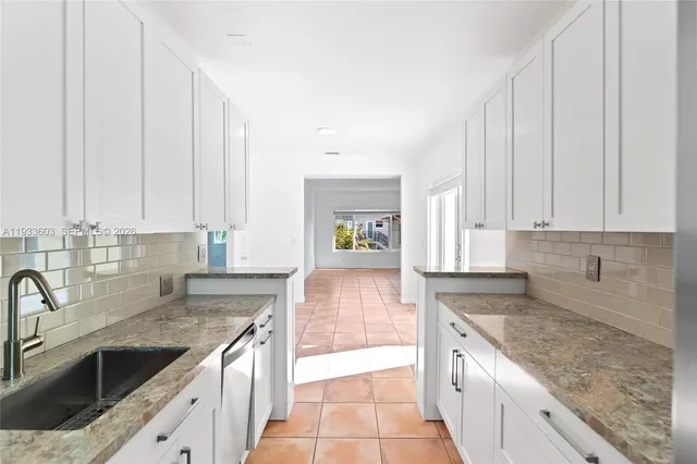 a kitchen with stainless steel appliances granite countertop a sink stove and cabinets