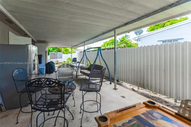 a roof deck with table and chairs and potted plants