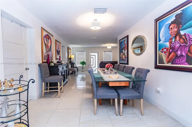a living room with furniture and paintings on the wall