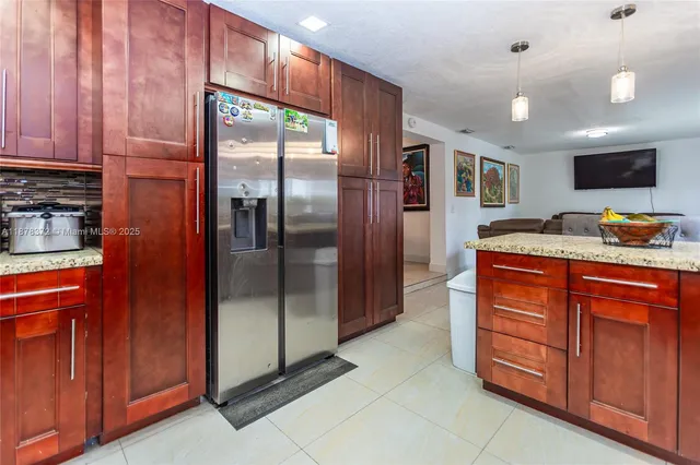 a kitchen with stainless steel appliances granite countertop a refrigerator and a sink