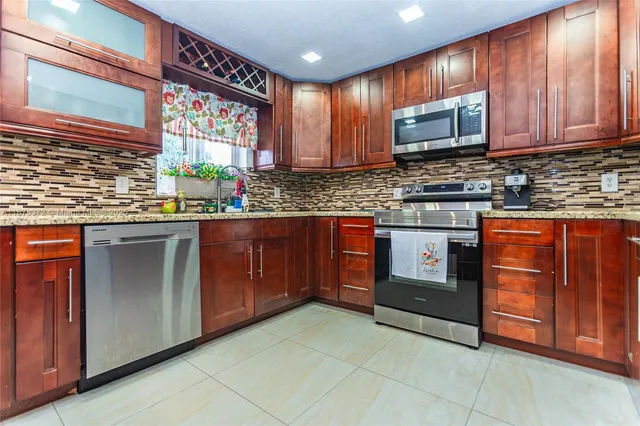 a kitchen with stainless steel appliances granite countertop wooden cabinets a sink and dishwasher