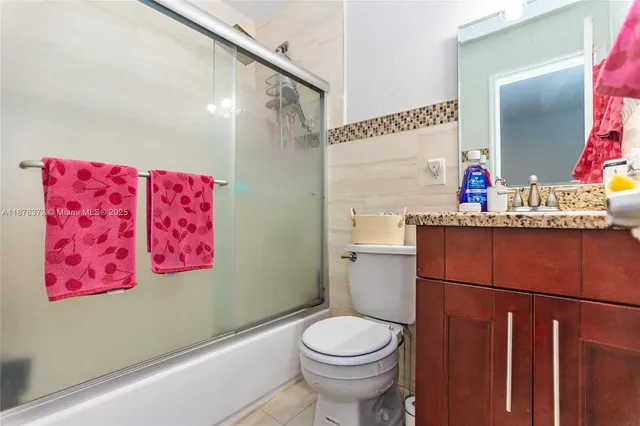 a bathroom with a sink mirror vanity and toilet