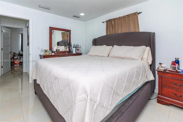 a large bed sitting in a bedroom next to a window