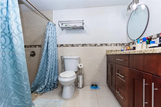 a bathroom with a granite countertop sink toilet and a mirror