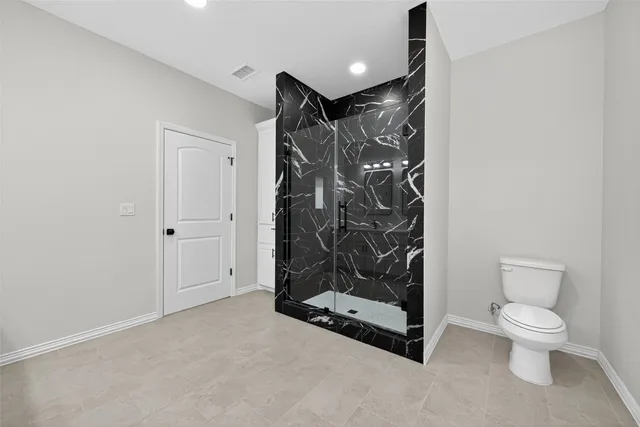 a bathroom with a toilet and shower