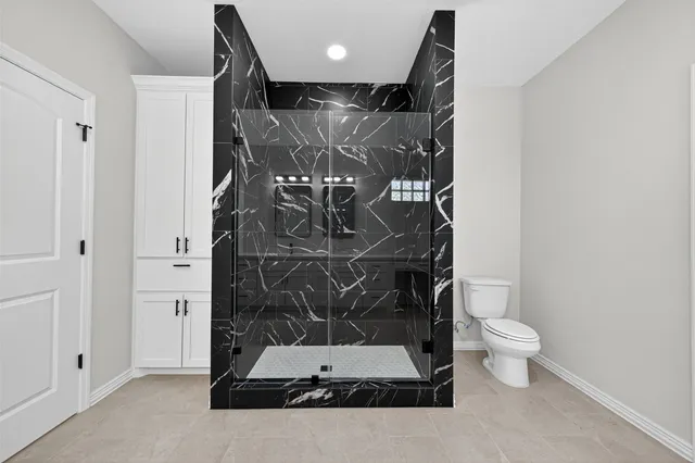 an empty room with wooden floor ceiling fan and windows