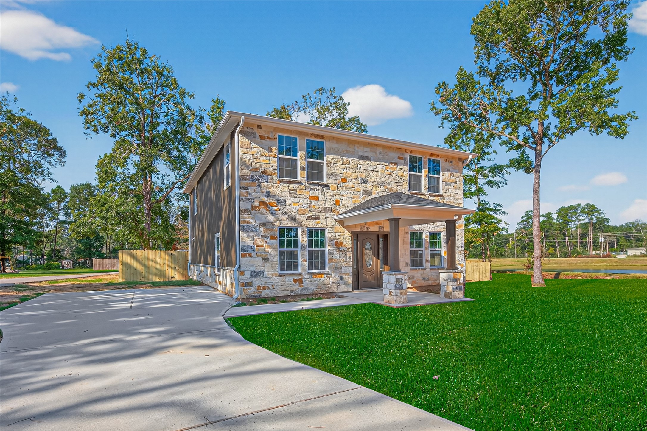 10594 Rustling Oaks Drive Conroe, TX 77303 - Photo 2 of 40 a front view of a house with garden and trees