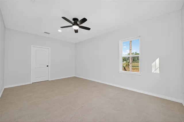 a view of an empty room with a ceiling fan