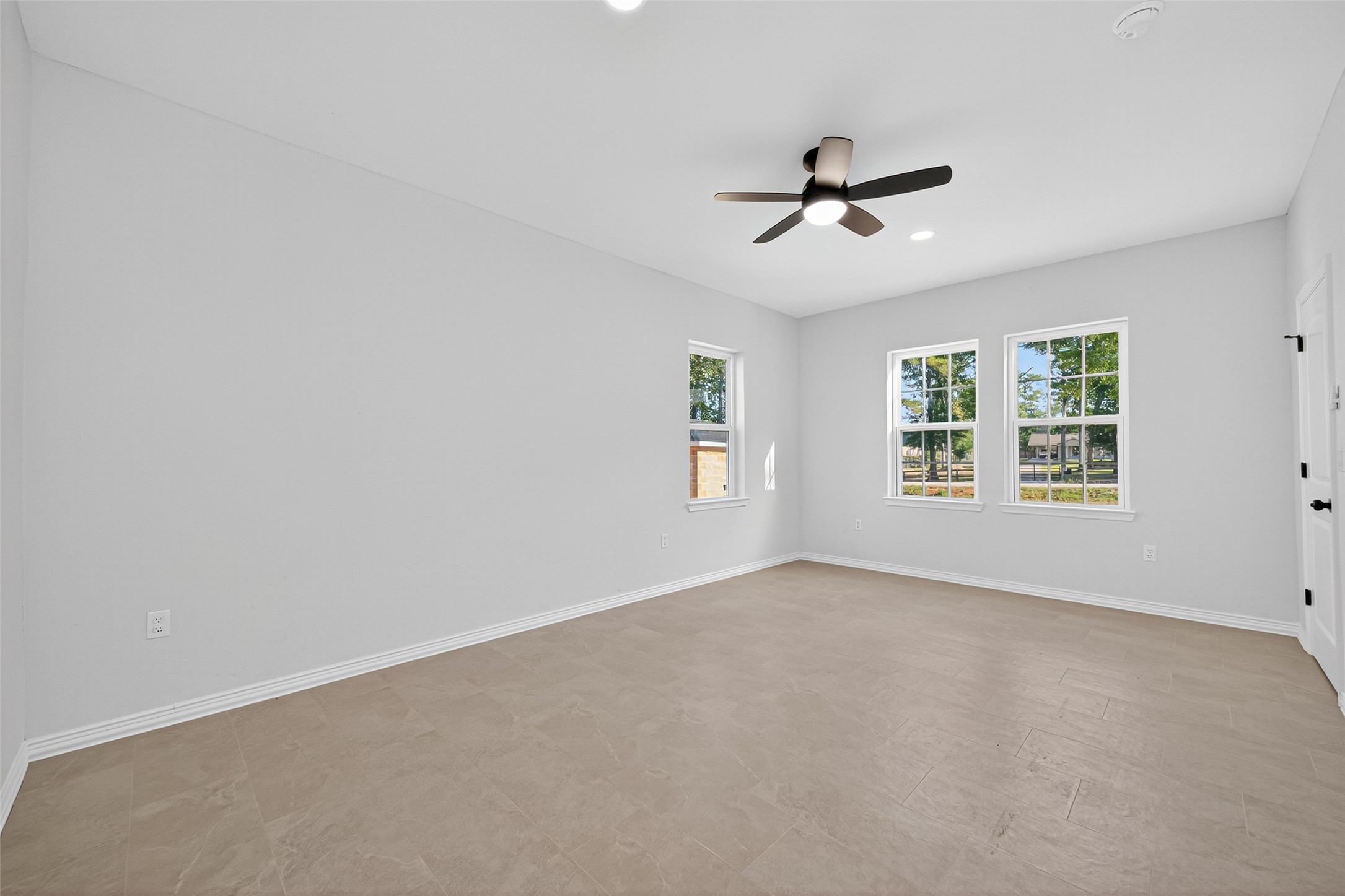 10594 Rustling Oaks Drive Conroe, TX 77303 - Photo 33 of 40 an empty room with windows and fan