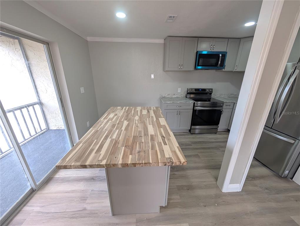 5521 Bay Boulevard, Unit 201 Port Richey, FL 34668 - Photo 5 of 12 a living room with furniture and a flat screen tv