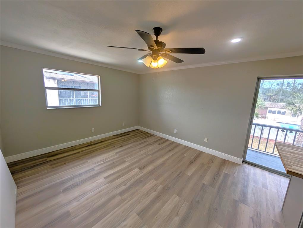 5521 Bay Boulevard, Unit 201 Port Richey, FL 34668 - Photo 6 of 12 a view of an empty room with wooden floor and a window