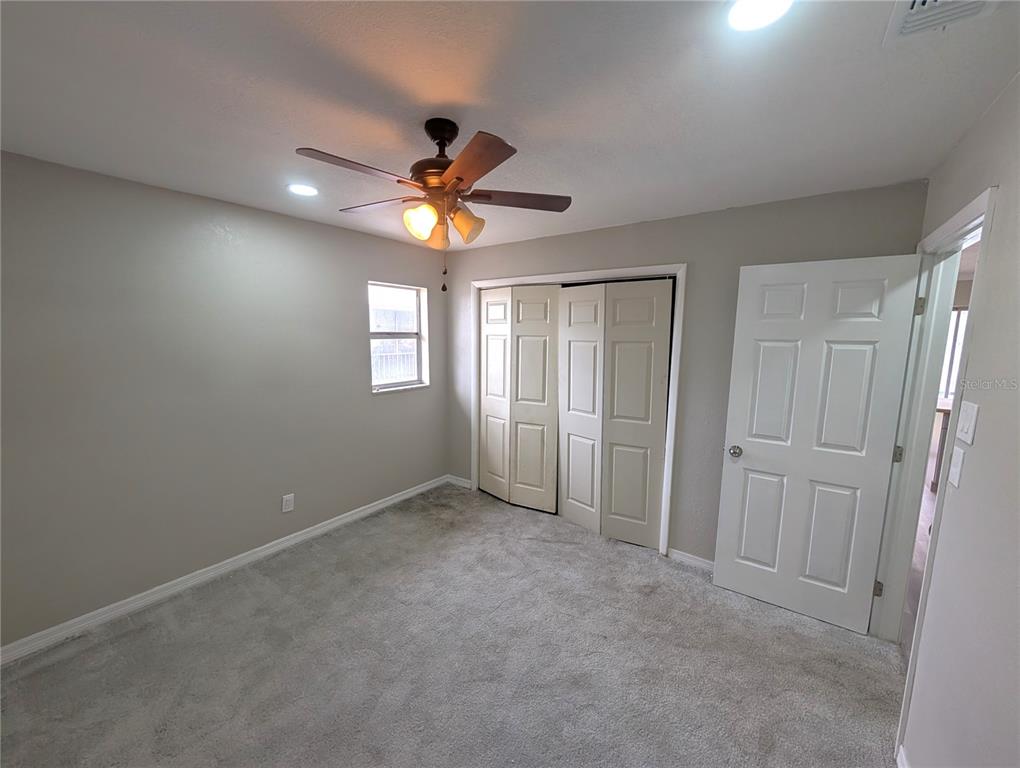 5521 Bay Boulevard, Unit 201 Port Richey, FL 34668 - Photo 8 of 12 an empty room with windows and fan