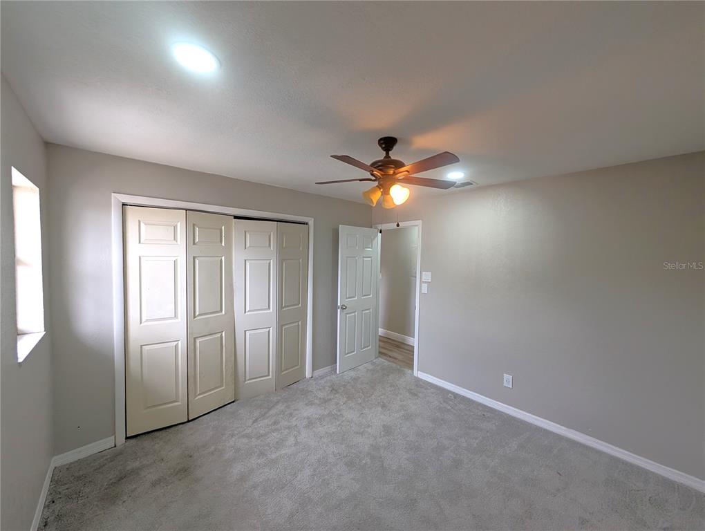 5521 Bay Boulevard, Unit 201 Port Richey, FL 34668 - Photo 9 of 12 an empty room with closet and a chandelier fan