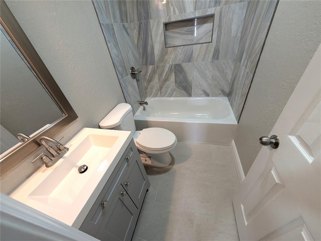 5521 Bay Boulevard, Unit 201 Port Richey, FL 34668 - Photo 10 of 12 a bathroom with a sink a toilet and a mirror