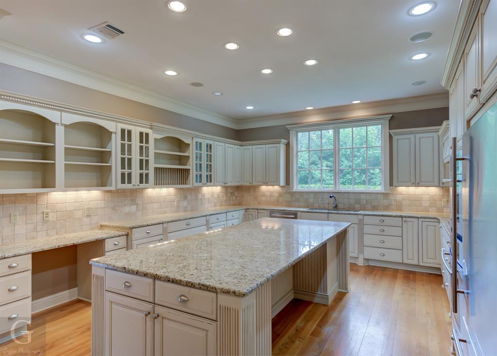 1212 WPA Road Homer, LA 71040 - Photo 25 of 35 Kitchen with open shelves, a sink, ornamental molding, a center island, and stainless steel refrigerator