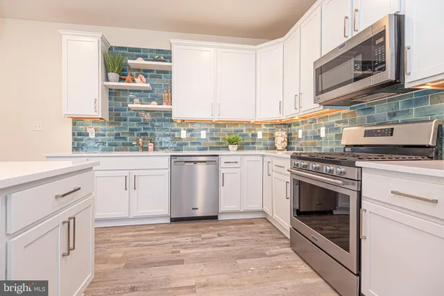 a kitchen with white cabinets stainless steel appliances and sink