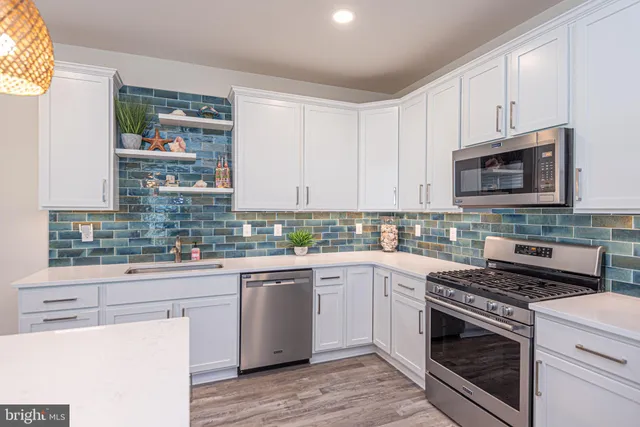 a kitchen with cabinets stainless steel appliances and a sink