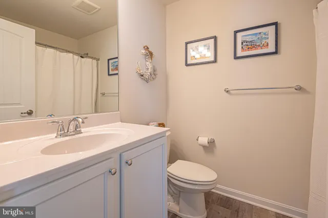 a bathroom with a sink mirror vanity and toilet
