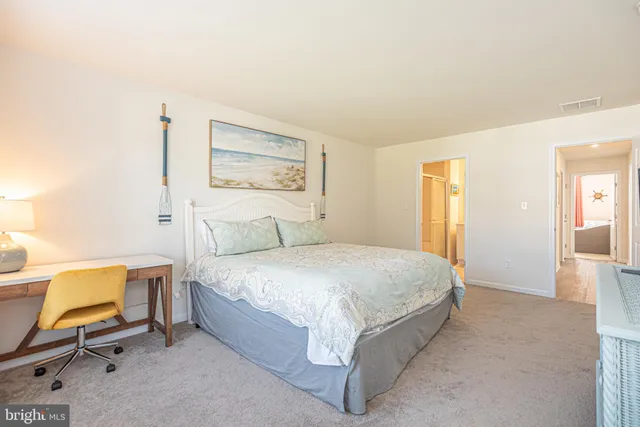 a spacious bedroom with a bed and chair