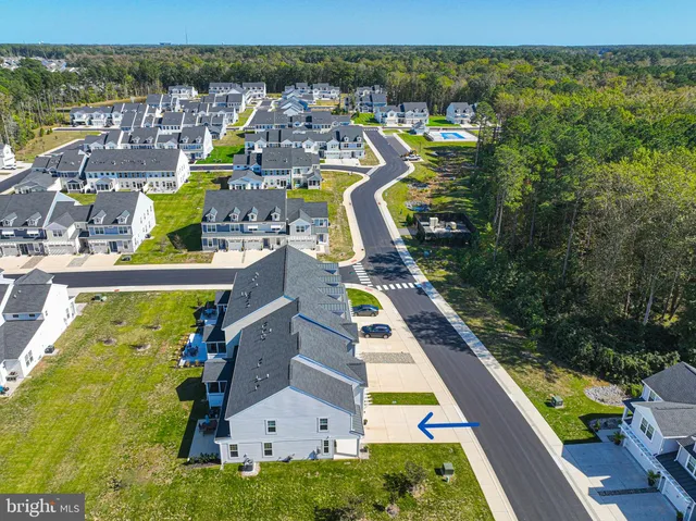 an aerial view of residential houses with outdoor space and swimming pool