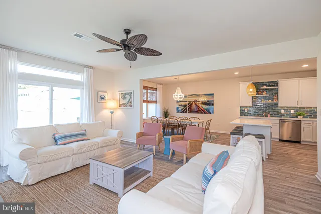 a living room with furniture kitchen view and a window