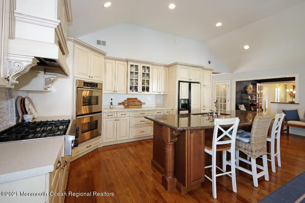 1132 Mohegan Road Manasquan, NJ 08736 - Photo 18 of 35 a kitchen with a table chairs stove and cabinets