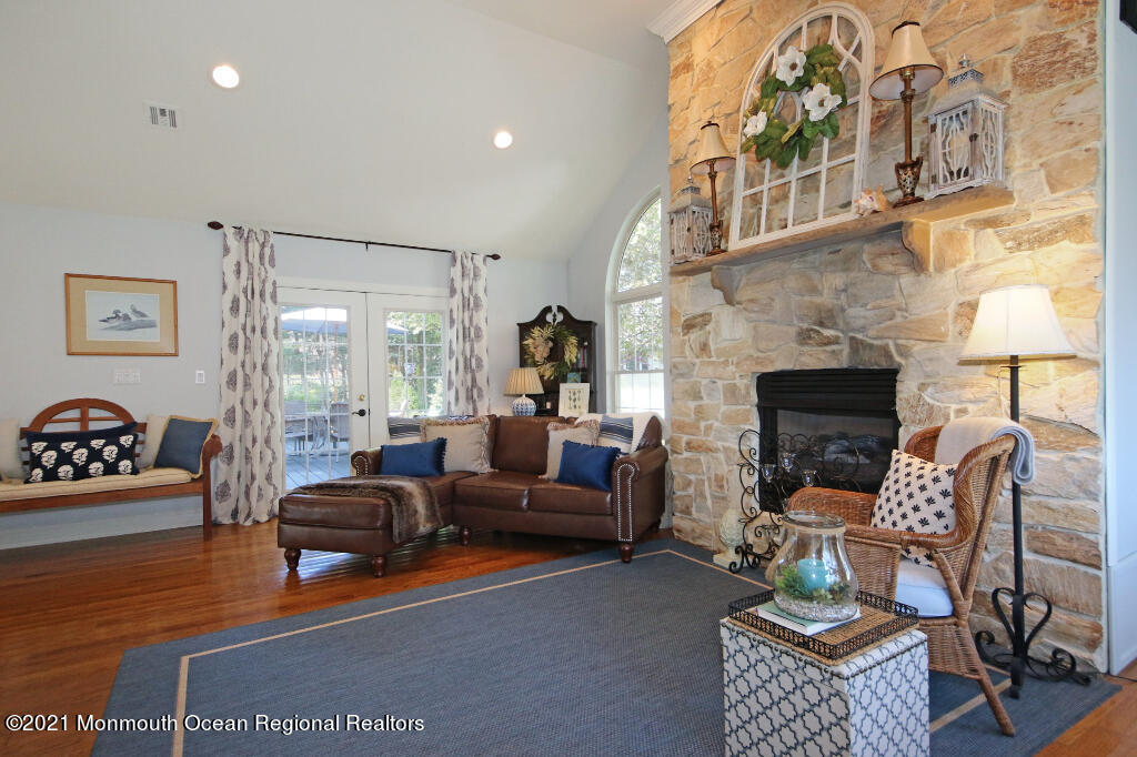 1132 Mohegan Road Manasquan, NJ 08736 - Photo 21 of 35 a living room with furniture a fireplace and a floor to ceiling window