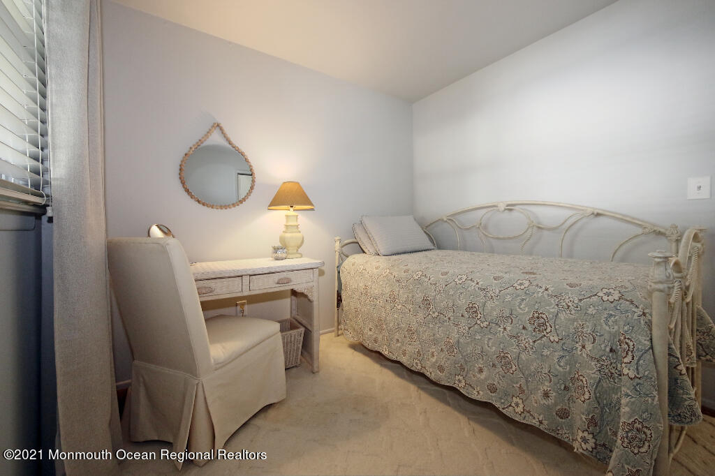 1132 Mohegan Road Manasquan, NJ 08736 - Photo 29 of 35 a living room with a bed furniture a fireplace and a window